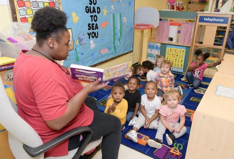 Child Development Center employee reading to children