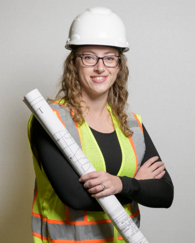 Smiling woman with hard hat and blueprint